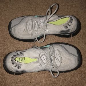 Grey Nike running shoes with a teal Nike symbol